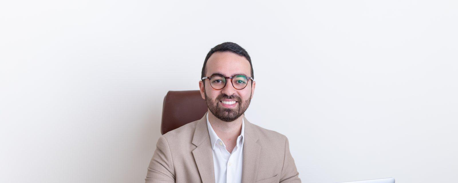 Dr. Leonardo à mesa do consultório, com o notebook aberto